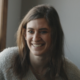 Woman recovering from addiction smiles while talking to counselor