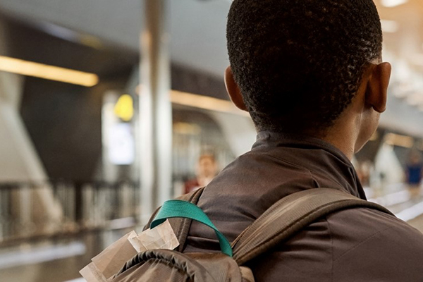 African refugee youth walking through an airport
