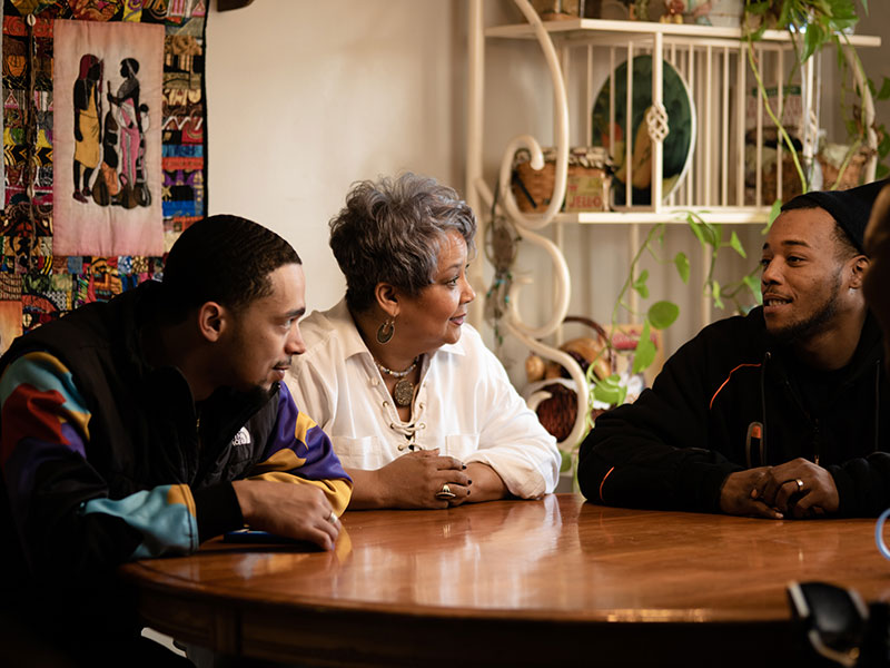 foster mother and young man smile at the dinner table