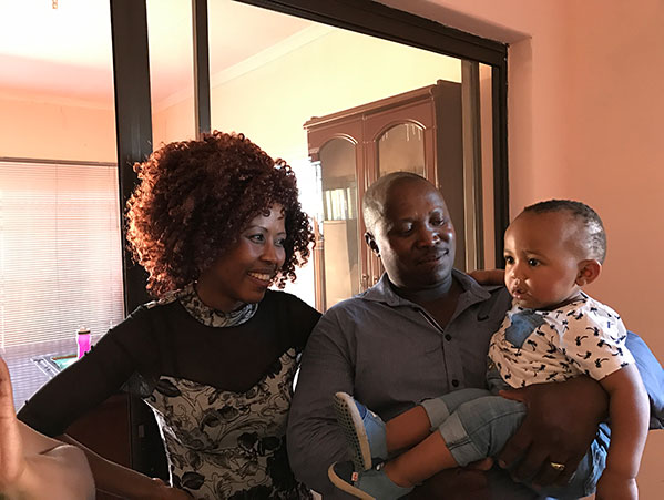 south african couple look lovingly at their adopted son